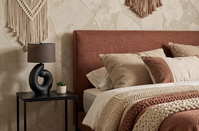 Coin chambre tendance avec tête de lit en lin terracotta, plaid bouclé et table de nuit en acier noir